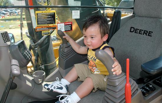 A young child pretends to drive a truck at the county's 'Touch-A-Truck' event