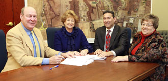 Clerk to the Board of Chosen Freeholders James S. Gray witnessed Freeholder Director Barbara J. McMorrow sign an agreement with Upper Freehold Twp. Mayor Stephen J. Alexander to swap roads in the township that will make way for improvements to Sharon Station Rd. Upper Freehold Twp. Clerk Barbara Bascom (far right) witnessed the signing for the township. 