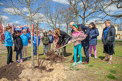 School children plant a tree on Arbor Day at the West Belmar School