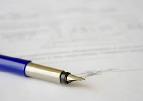 A pen laying on a signed contract