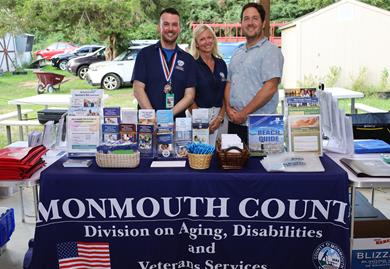 Monmouth County Employees from the Division on Aging, Disabilities & Veterans Services behind their table at the resource fair Monmouth County Employees from the Division on Aging, Disabilities & Veterans Services behind their table at the resource fair