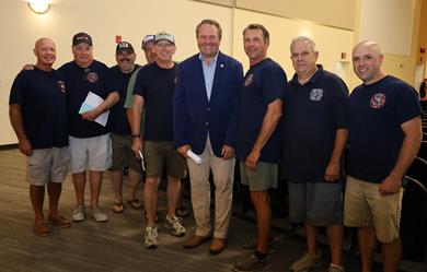 Commissioner Anderson in a group photo with firefighters at the caucus meeting