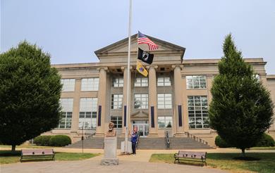 a photo of the flags in front of the Monmouth County Courthouse being lowered to half-staff